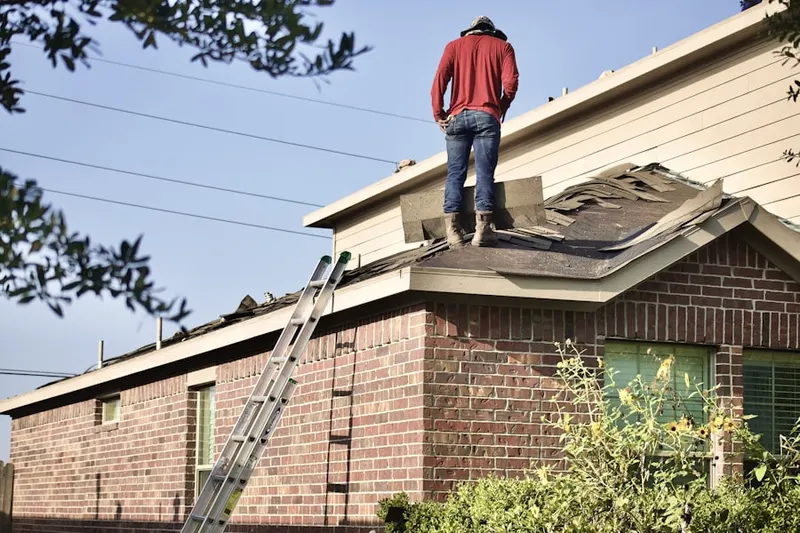 Professional roofer working on a residential roof in Woodtick